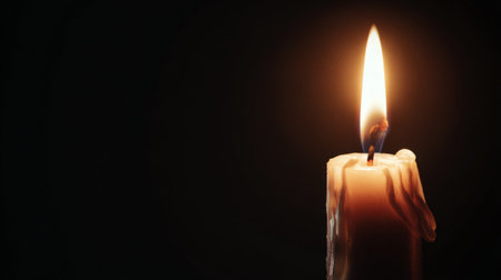 Candle flame illuminates dark space in serene setting, creating a warm and peaceful atmosphere during evening hoursの素材