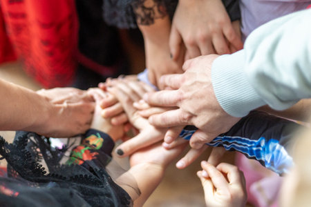 Hands joining together in a circle during a community gathering celebrating unity and togethernessの写真素材
