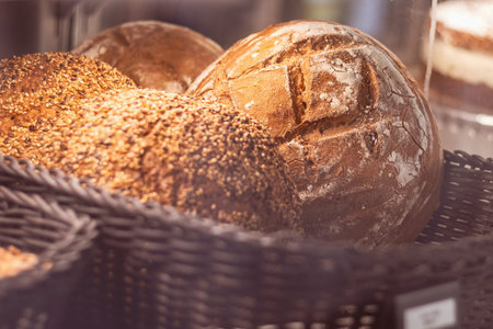 Warm artisan bread rolls in a rustic basket basking in morning light at a local bakery