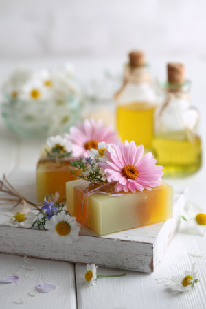 Handmade natural soap with flowers and essential oils displayed on a rustic wooden surfaceの素材