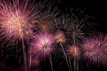 Fireworks light up the night sky in vibrant colors during a summer celebration in the cityの素材