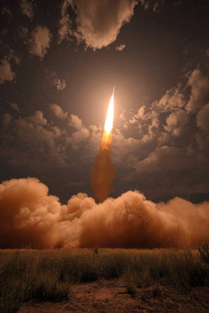 Rocket launches into the sky, illuminating the night with bright flames and billowing clouds of smokeの素材