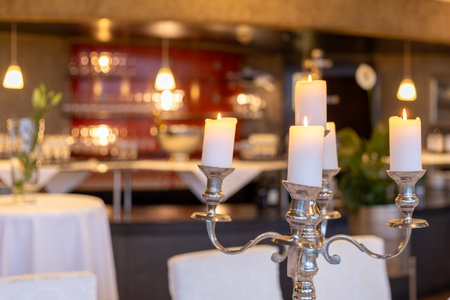 Elegant dining setup with candles in a cozy restaurant setting during the eveningの写真素材