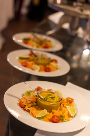 Delicious salmon dishes served at a gourmet event with fresh vegetables and herbs for a balanced...