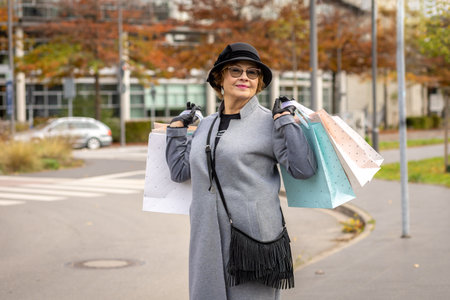 Stylish woman enjoying a shopping day in the city with colorful bags in autumnの写真素材