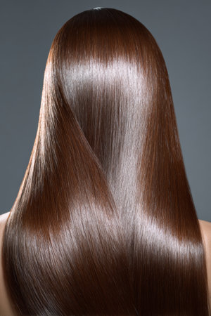 Long, shiny brunette hair styled for a glamorous look during a beauty sessionの素材