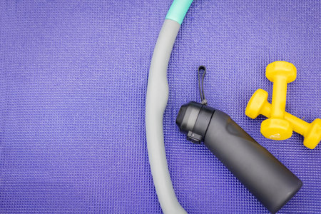 Fitness equipment arranged on a purple exercise mat during daytimeの写真素材