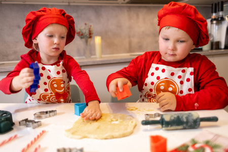 Kids baking cookies together during the holiday season in a cozy kitchen decorated with festive elementsの写真素材