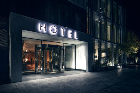 Modern hotel entrance illuminated at night with elegant design and welcoming ambiance in vibrant urban settingの素材