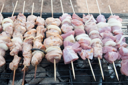 grilled and raw shish kebab cooked on barbecue outdoorの写真素材