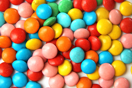 bright colorful round candy M & M's and chocolate eggs on white background bright colorful round candy M & M's and chocolate eggs on white background