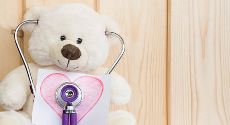 white teddy bear listens to its heartbeat. medicine conceptの写真素材