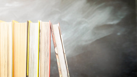 five books are in a row on the background of the school board