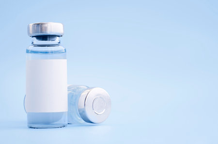 two vials of vaccine on a light blue backgroundの写真素材