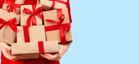 a woman holds a multitude of gift boxes in her hands on a light blue background. sale conceptの写真素材