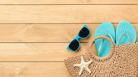 beach bag with sunglasses and flip flops on wooden backgroundの写真素材