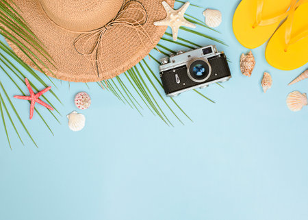 sun hat, palm leaf, flip flops and seashells on a light blue background. summer backgroundの写真素材