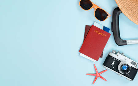 suitcase, passport, tickets, sunglasses, sun hat and starfish on a light blue background. travel conceptの写真素材