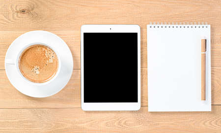coffee cup, digital tablet, notebook and pen on a wooden background. view from aboveの写真素材