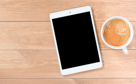digital tablet with copy space and coffee mug on wooden table