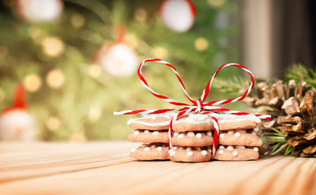 gingerbread cookies tied with a Christmas bow on a wooden table against the background of a...