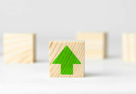 wooden cube with a drawn green arrow up, the concept of growth and riseの写真素材