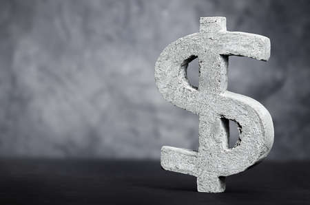 concrete dollar sign on dark gray backgroundの写真素材
