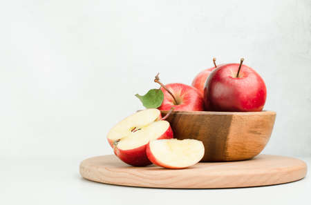 wooden plate with fresh red apples on a light backgroundの写真素材