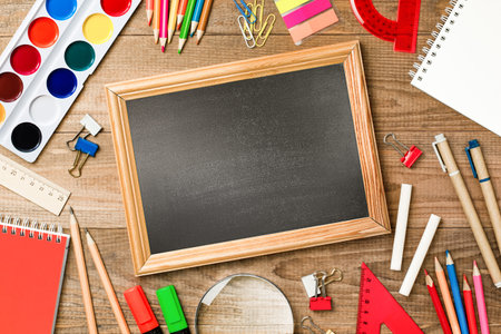 blackboard with copy space and stationery on wooden table