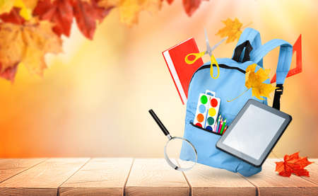 backpack and various school supplies on autumn natural background, back to schoolの写真素材