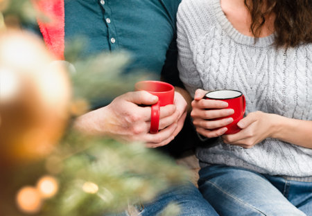 man and woman holding hot christmas drinksの写真素材