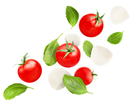 levitation of cherry tomatoes, basil leaves and mozzarella on a white isolated backgroundの写真素材