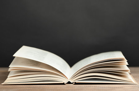 open book on table against black chalkboard backgroundの写真素材