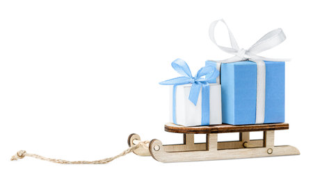 wooden sledge with gift boxes on a white isolated backgroundの写真素材