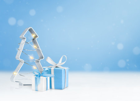 Christmas figurine in the shape of a fir tree and two gift boxes on a blue background with copy spaceの写真素材
