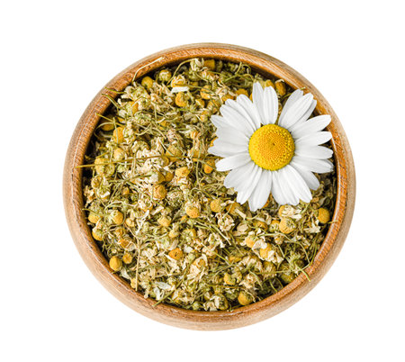 wooden plate with dry chamomile on a white isolated background, top viewの写真素材