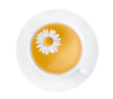 white saucer and mug with chamomile tea. on a white isolated background, top viewの写真素材
