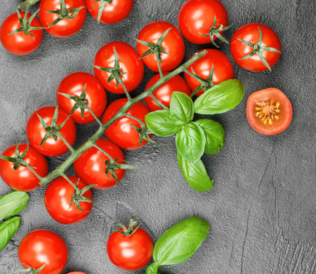 cherry tomatoes and basil close-up on a concrete background, top viewの写真素材