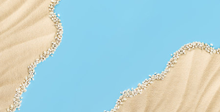 summer background with sand and seashells on the edges and a blue background in the center for copy spaceの写真素材