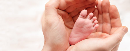 tiny baby foot in daddy's palms. family conceptの写真素材
