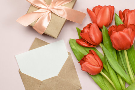 composition of red tulips, gift box and letter in an envelopeの写真素材
