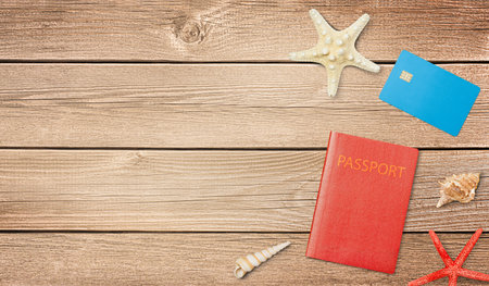passport, credit card and shells with starfish on wooden background, top viewの写真素材