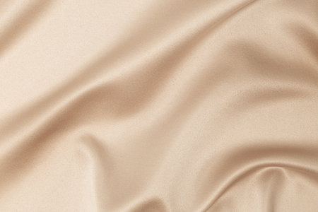 beige silk fabric background with foldsの写真素材