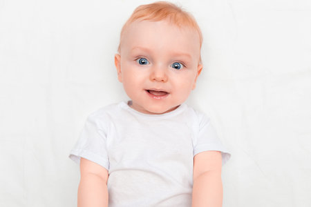 Portrait of a cute seven month old baby lying down smiling and looking at the camera