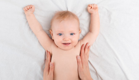 mother's hands caressing a happy babyの写真素材