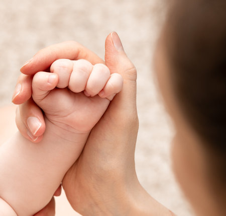 mother's hand holds baby's handの写真素材