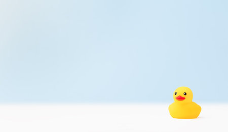 light blue background with a yellow rubber duckの写真素材