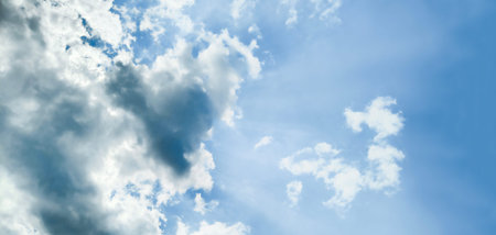 The sun behind the clouds in the blue sky. Natural backgroundの写真素材