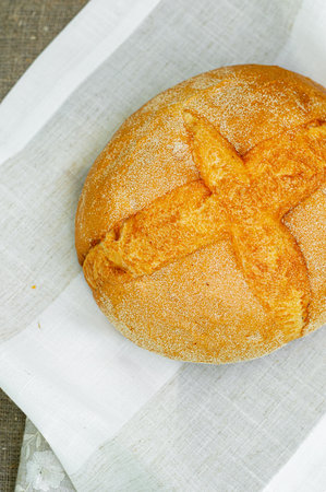 Close-up of whole fresh crispy tasty round shaped wheat bread on a light background. Individual items, baking, side view, top viewの写真素材