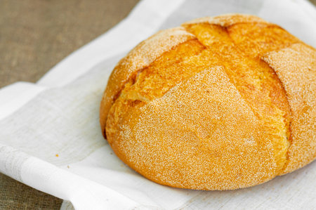Close-up of whole fresh crispy tasty round shaped wheat bread on a light background. Individual items, baking, side view, top viewの写真素材